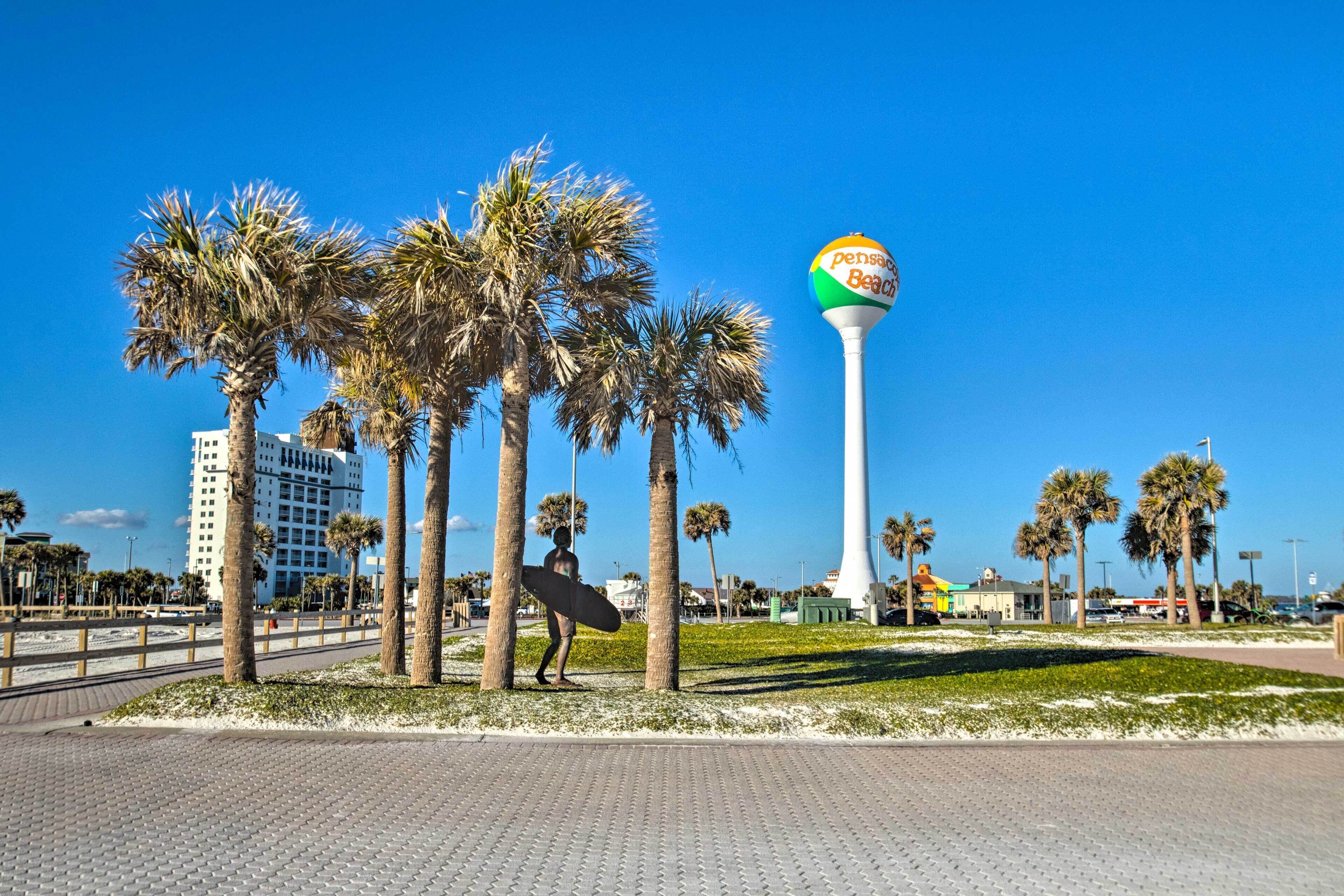 A beachside promenade with palm trees, a lifeguard tower, and a surfboard.