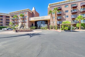 A multi-story building with a sign reading 'Queens Bay Resort Condominiums.' - Walk to Beach: Top-floor Condo in Lake Havasu City (Lake Havasu City)