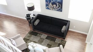 A modern living room with a black sofa, two armchairs, a coffee table, and a patterned rug. -  Luxury Oasis Near the Las Vegas Strip – Sleeps Large Groups in Style (Las Vegas)