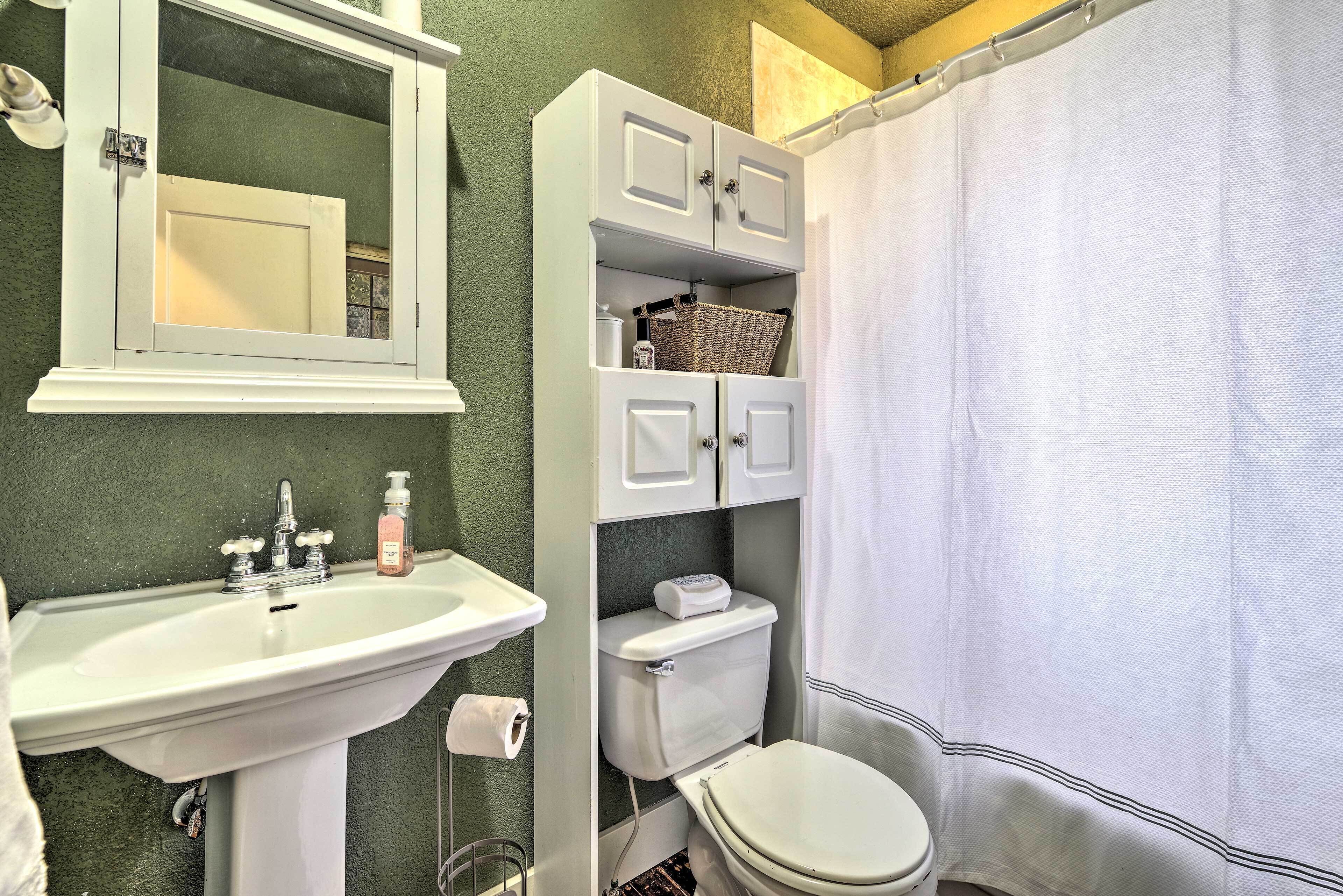A bathroom with a white sink, a toilet, and a shower curtain.