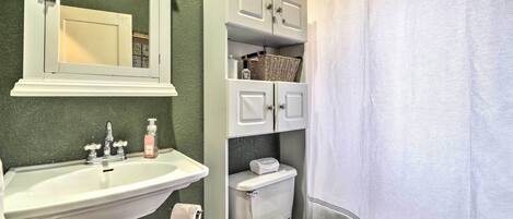 A bathroom with a white sink, a toilet, and a shower curtain.
