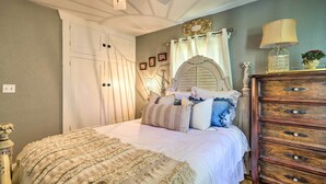 Un dormitorio con cama, cómoda y ventilador de techo.