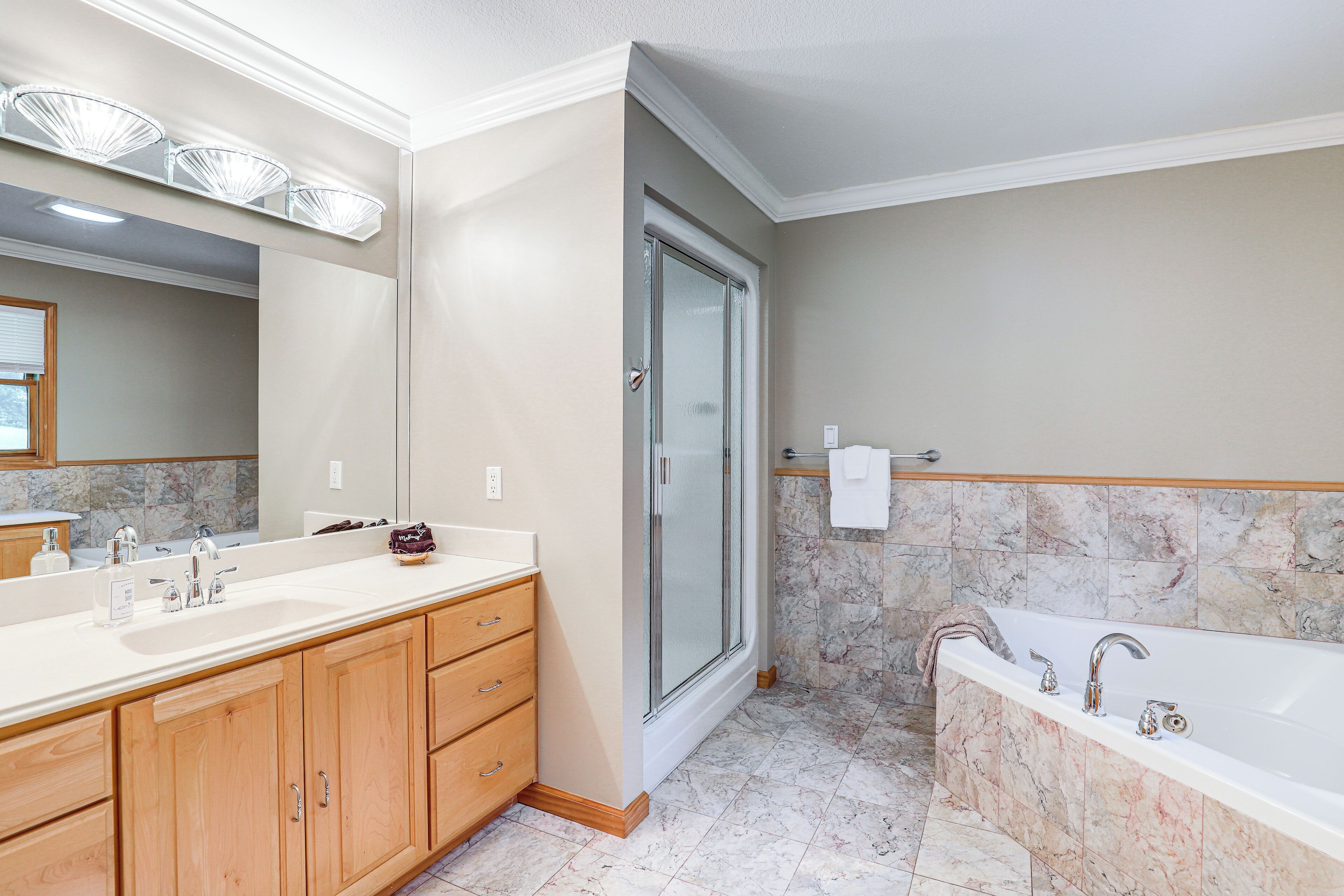 A modern bathroom with a large vanity, a separate shower area, and a bathtub.