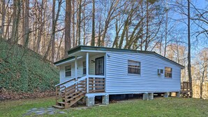A small, single-story cabin with a porch and a staircase leading to the entrance. - Secluded Bryson City Home w/ Deck, Steps to Creek! (Bryson City)