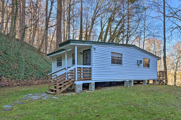 A small, single-story cabin with a porch and a staircase leading to the entrance.