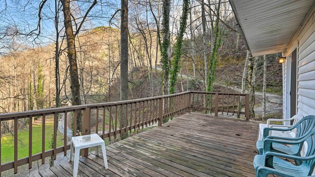 A wooden deck with a railing, a small white stool, and blue chairs. - Secluded Bryson City Home w/ Deck, Steps to Creek! (Bryson City)