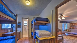 A cozy room with bunk beds, a wooden desk, and a sofa. - Secluded Bryson City Home w/ Deck, Steps to Creek! (Bryson City)