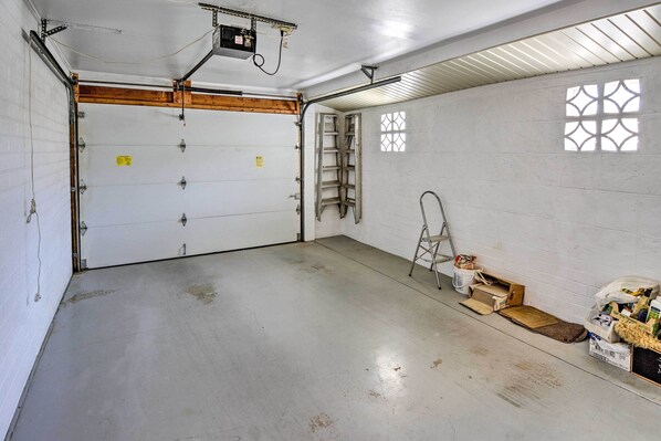 Un garage avec deux portes fermées, une échelle et divers matériaux de construction éparpillés sur le sol.