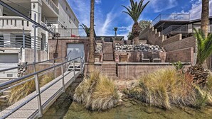 A multi-level building with outdoor staircases, a water feature, and palm trees. - Restful Riverfront Retreat w/ Private Dock + Patio (Bullhead City)