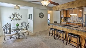 A kitchen with a wooden island, bar stools, and a ceiling fan. - Restful Riverfront Retreat w/ Private Dock + Patio (Bullhead City)