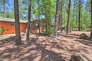 A cabin with a wooden exterior, surrounded by tall trees and a clear sky. - Peaceful Mountain Getaway in the Pines! (Pinetop)