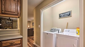 A laundry room with a washing machine, dryer, and a sign for 'Huff and Fota Laundry Service Co.' - 1 Mi to Parkway! Flat-access Pigeon Forge Condo (Pigeon Forge)