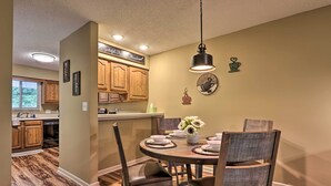 A dining area with a round table, chairs, and a hanging light fixture. - 1 Mi to Parkway! Flat-access Pigeon Forge Condo (Pigeon Forge)