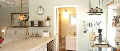 A spacious kitchen with a large island, a dining area with a chandelier, and a visible clock on the wall.