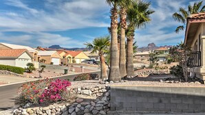 A residential area with houses, palm trees, and a clear sky.