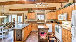 A spacious kitchen with wooden cabinets, a large island, and modern appliances. - Relax Fireside! Peaceful Forest Haven in Prescott (Prescott)