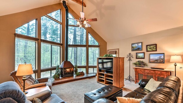 A spacious living room with a fireplace, large windows, and a cozy seating area. - Relax Fireside! Peaceful Forest Haven in Prescott (Prescott)