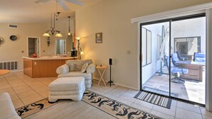 A modern living room with a large sliding glass door leading to a patio area. - Walk to NFL Games: Glendale Home Near Golf (Glendale)