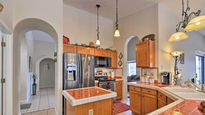 A modern kitchen with stainless steel appliances, wooden cabinets, and a red tile backsplash. - Walk to NFL Games: Glendale Home Near Golf (Glendale)