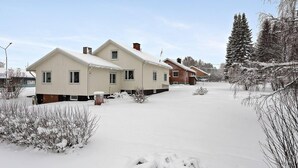 Una hilera de casas de dos pisos con un paisaje nevado.