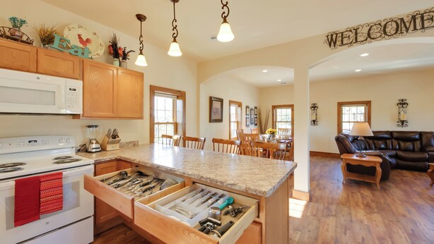 A kitchen with wooden cabinets, a built-in microwave, and a center island with drawers.