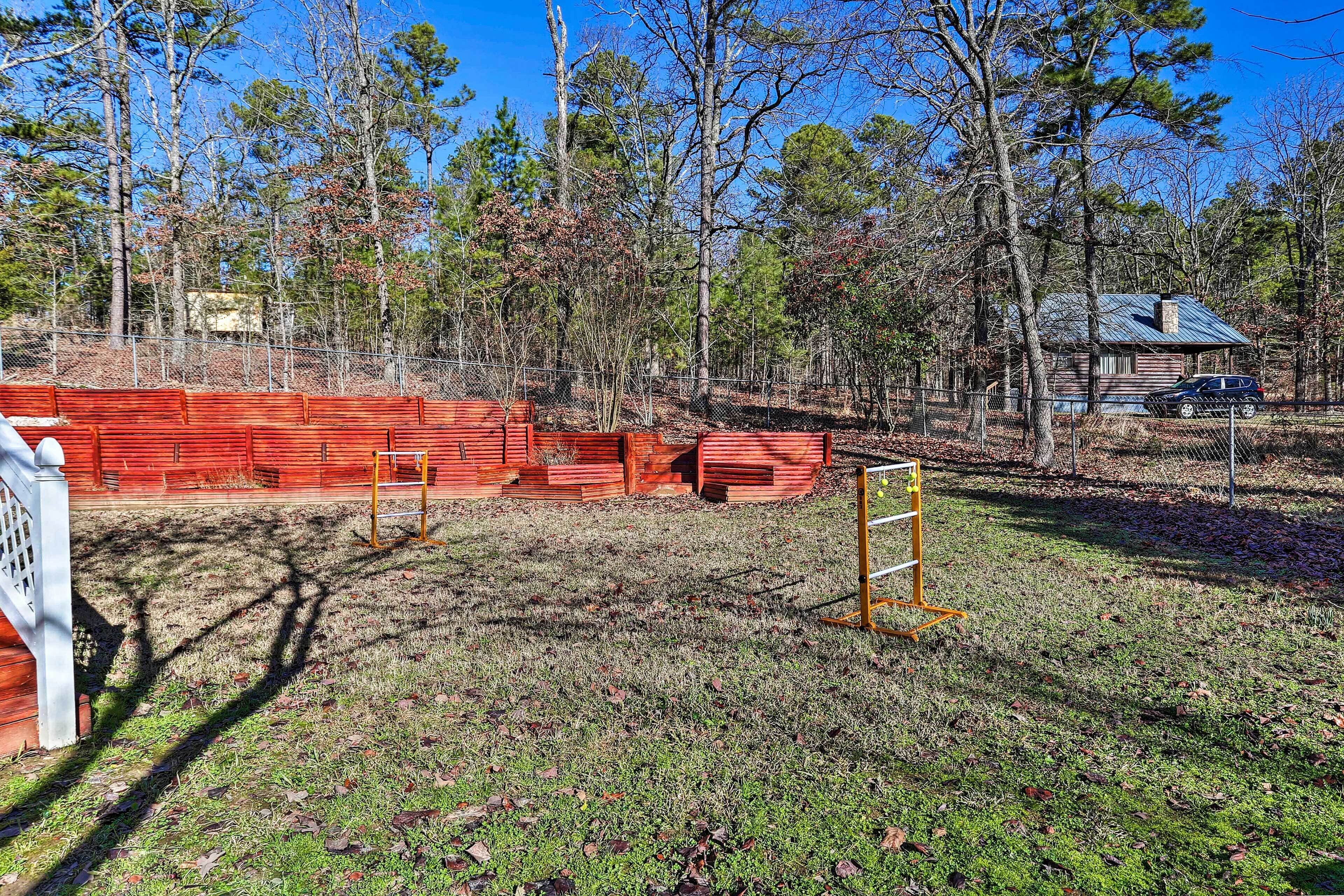 A fenced outdoor area with a wooden cabin in the background.