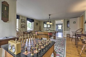Um quarto com mesa de bilhar, jogo de damas e mesa de sinuca.