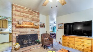 A living room with a stone fireplace, a television, and a wooden coffee table. - 10 Mi to Show Low: Pinetop-lakeside Family Cabin! (Lakeside)