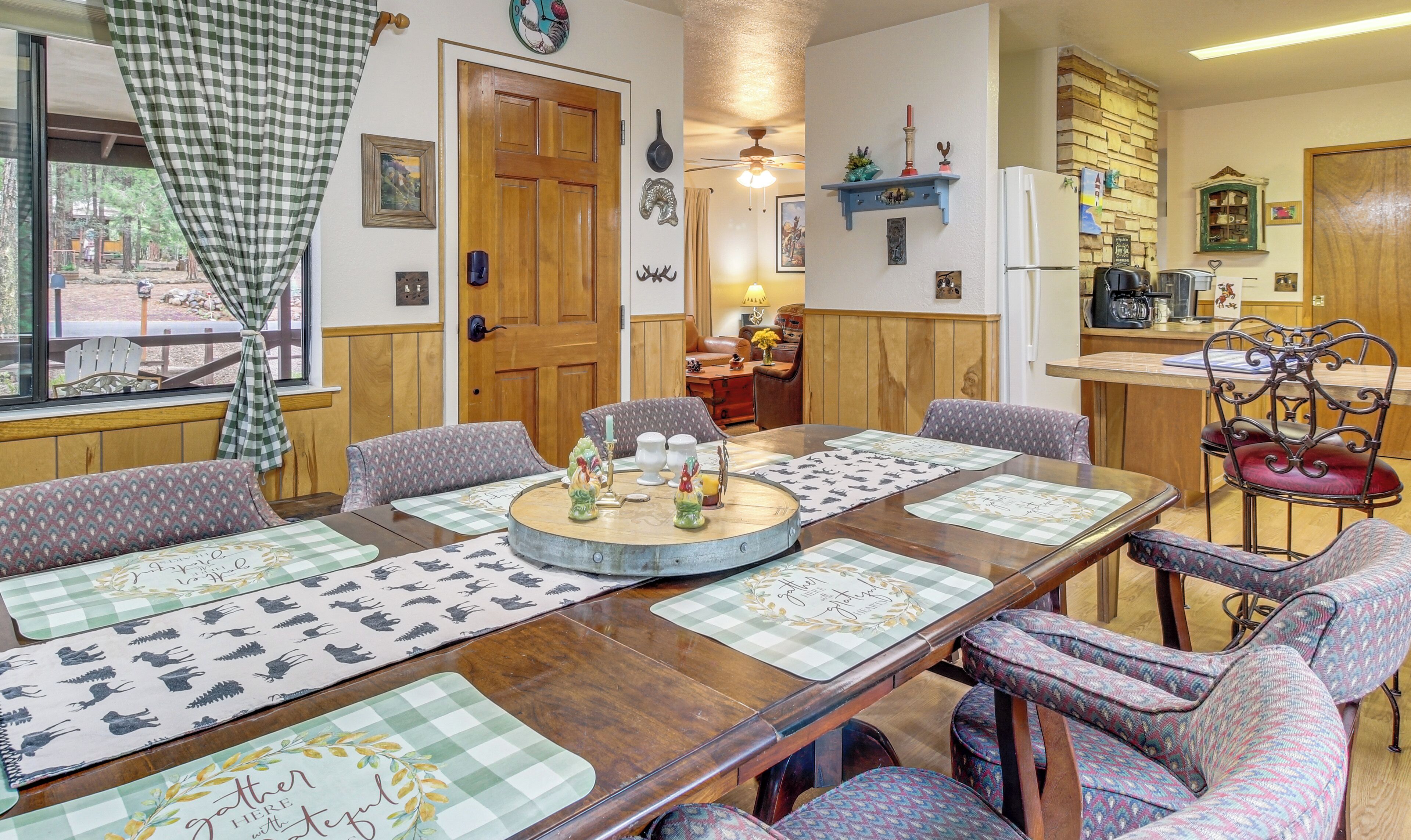 Un comedor con una mesa de madera, individuales estampados y sillas tapizadas.