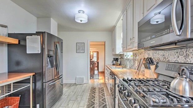 Una cocina moderna con electrodomésticos de acero inoxidable, encimera de madera y salpicadero estampado.