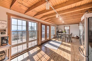Una cocina amplia con ventanas grandes, pisos de madera y un techo alto.