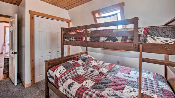 A bunk bed with a quilted bedspread, a wooden ceiling, and a window with natural light. - Rural Dutch Country Retreat - Private Hot Tub (Mount Pleasant Mills)