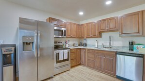 A modern kitchen with stainless steel appliances, wooden cabinets, and a granite countertop. - Tucson Home ~ 8 Mi to Saguaro National Park (Tucson)