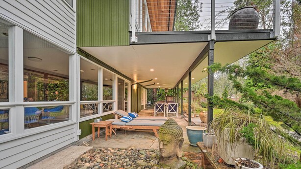 A modern house with a covered patio, outdoor seating, and a stone Buddha statue. - Edmonds Apartment With Private Wine Cellar! (Edmonds)