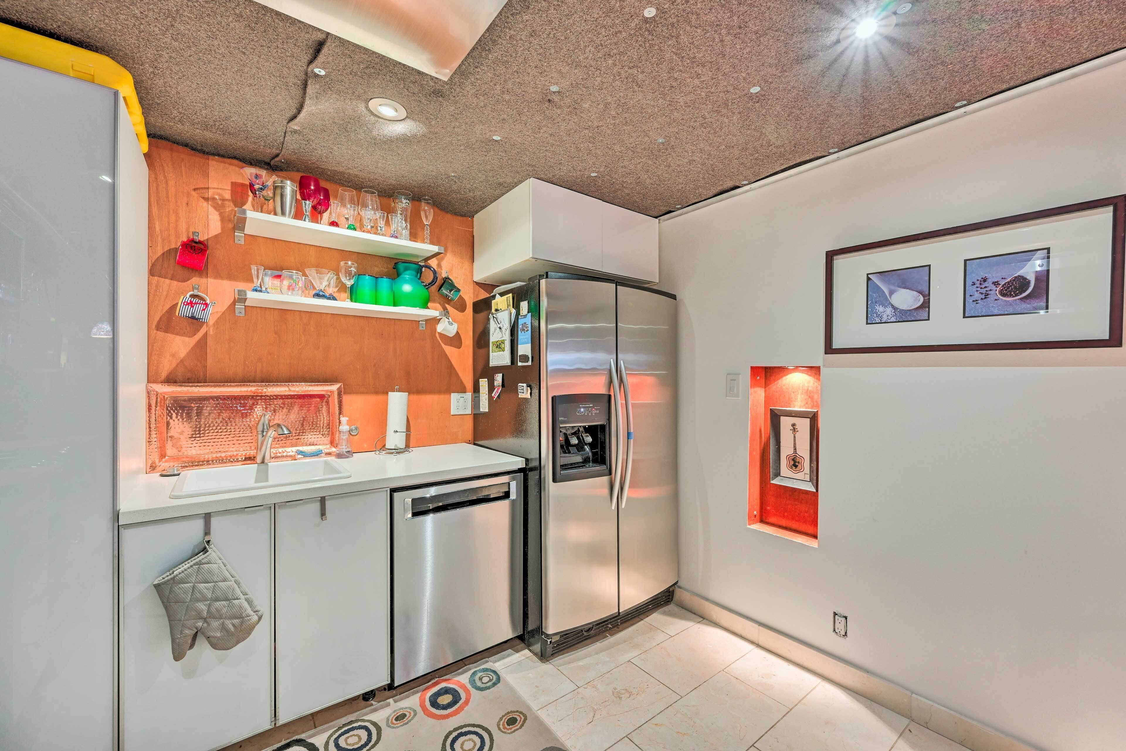 A modern kitchen with a built-in dishwasher, a refrigerator, and a countertop with various kitchen items.