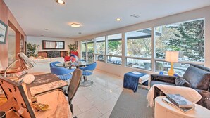 A spacious living room with a fireplace, large windows, and modern furniture. - Edmonds Apartment With Private Wine Cellar! (Edmonds)