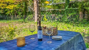 A table set outdoors with a bottle of wine, glasses, and a basket. - Guest Cottage on 1 Acre: 20 Mins to Asheville! (Black Mountain)