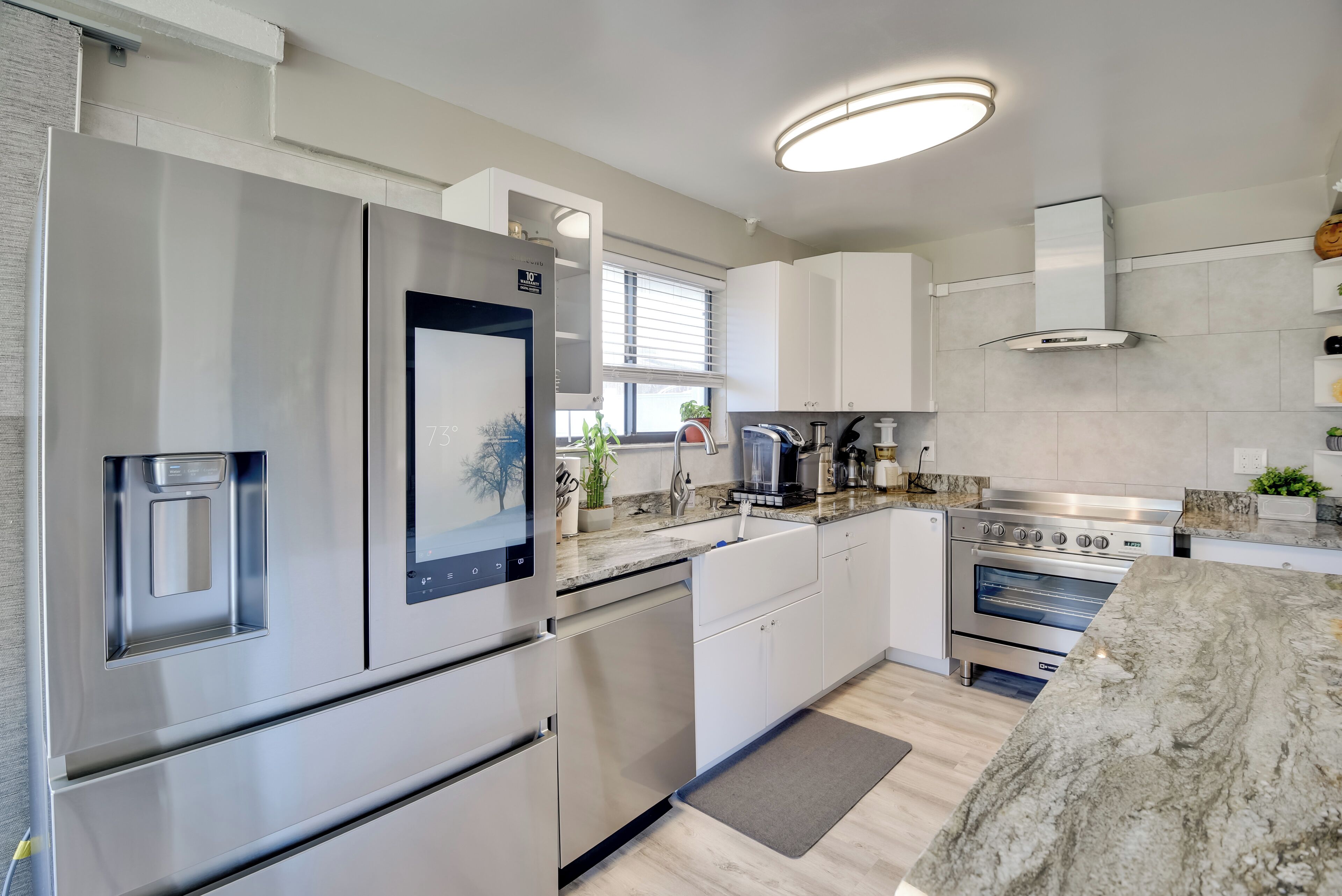 A modern kitchen with stainless steel appliances, a built-in oven, and a granite countertop.