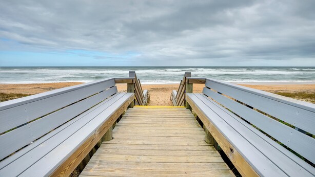 A wooden boardwalk leading to a beach with a cloudy sky. - Bright Ormond Beach Home ~ 14 Mi to Daytona! (Ormond Beach)