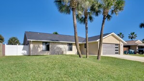 A single-story house with a stone facade, a garage, and a well-maintained lawn with two palm trees. - Bright Ormond Beach Home ~ 14 Mi to Daytona! (Ormond Beach)