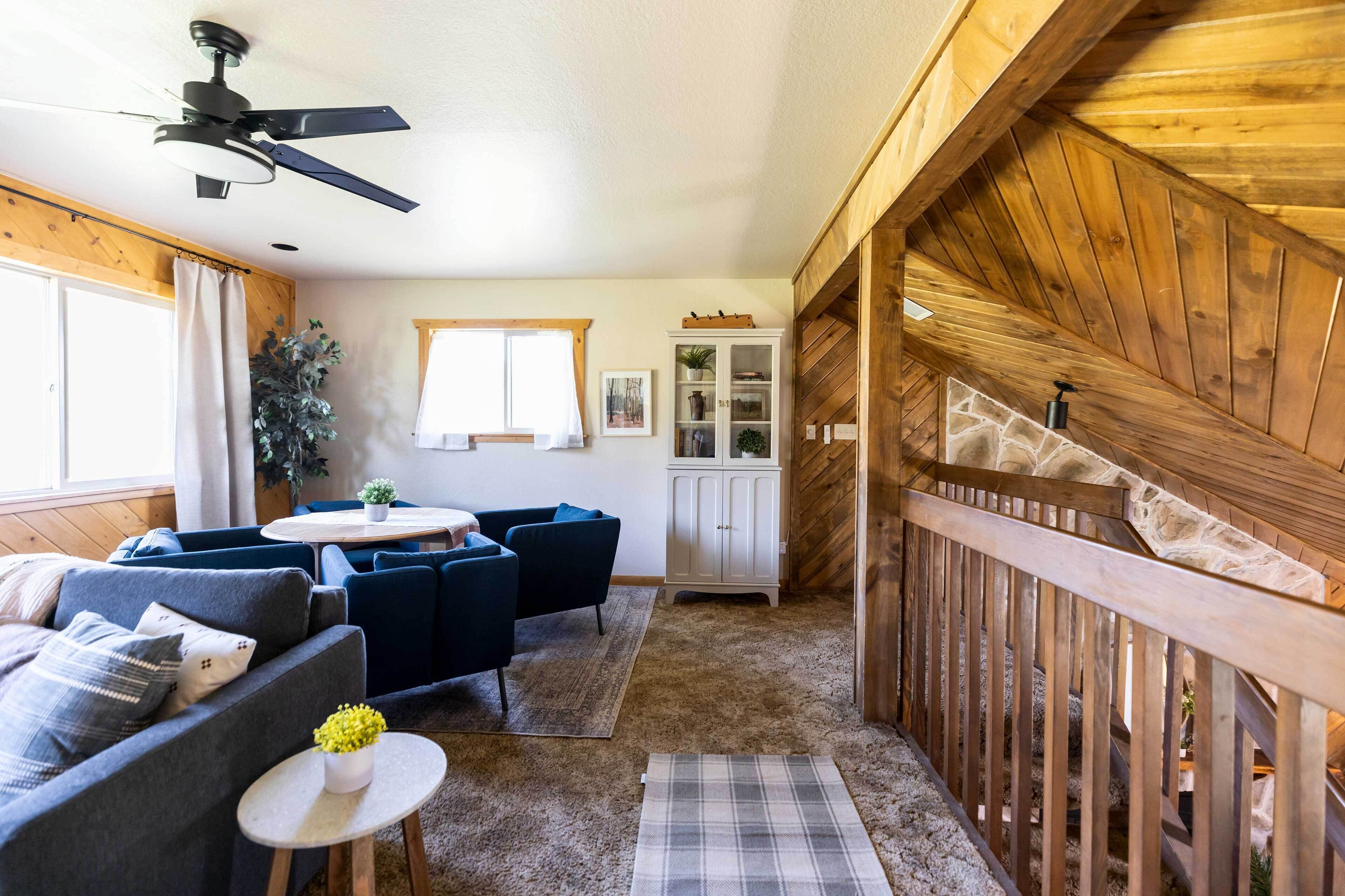 A cozy room with a ceiling fan, a dining area with a table and chairs, a sofa, and a cabinet.