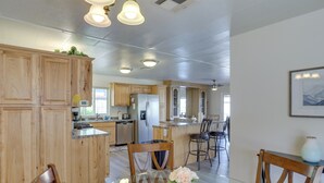 Una cocina moderna con armarios de madera, una mesa de comedor con sillas y una isla grande con fregadero.