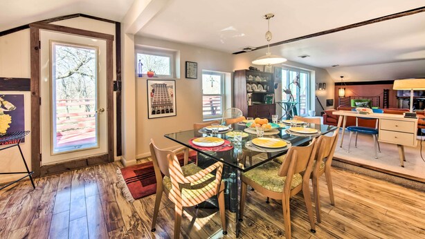 A dining area with a glass table, wooden chairs, and a view of the outdoors. - Creek Access & Deck: Runningwater Lancaster Gem (Lancaster)