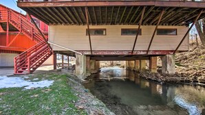 A building with a metal staircase and a bridge over a small stream. - Creek Access & Deck: Runningwater Lancaster Gem (Lancaster)