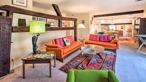 A living room with two orange sofas, a green armchair, a coffee table, and a patterned rug. - Creek Access & Deck: Runningwater Lancaster Gem (Lancaster)