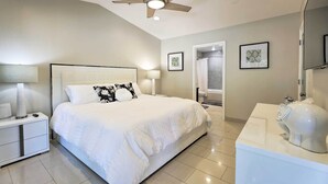 A bedroom with a bed, nightstand, lamp, ceiling fan, bathroom mirror, and a toilet with a decorative jug. - Outdoor Kitchen: Desert Dream Home in Scottsdale! (Scottsdale)