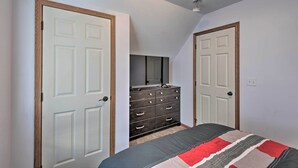 A bedroom with a bed, a dresser, and two doors. - Cozy Cedar Rapids Pad - 2 Blocks to Mercy Care! (Cedar Rapids)