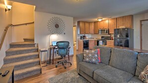 A modern kitchen with wooden cabinets, a microwave, and a refrigerator. - Cozy Cedar Rapids Pad - 2 Blocks to Mercy Care! (Cedar Rapids)