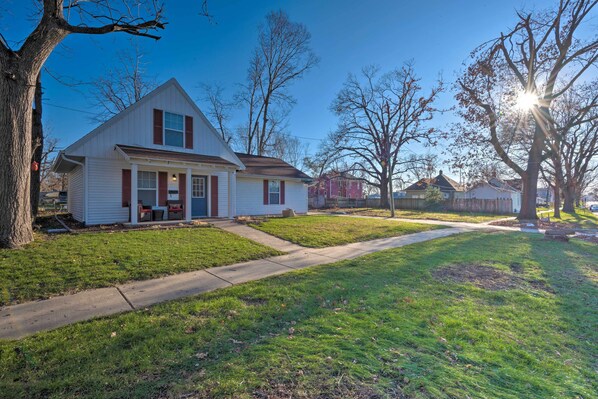 A single-story house with a front porch, a lawn, and a clear sky.