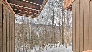 Eine Holzhütte mit Blick auf einen verschneiten Wald.